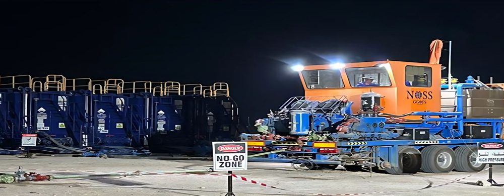 NOSS pumping unit and tanks rigged up for a stimulation job at night